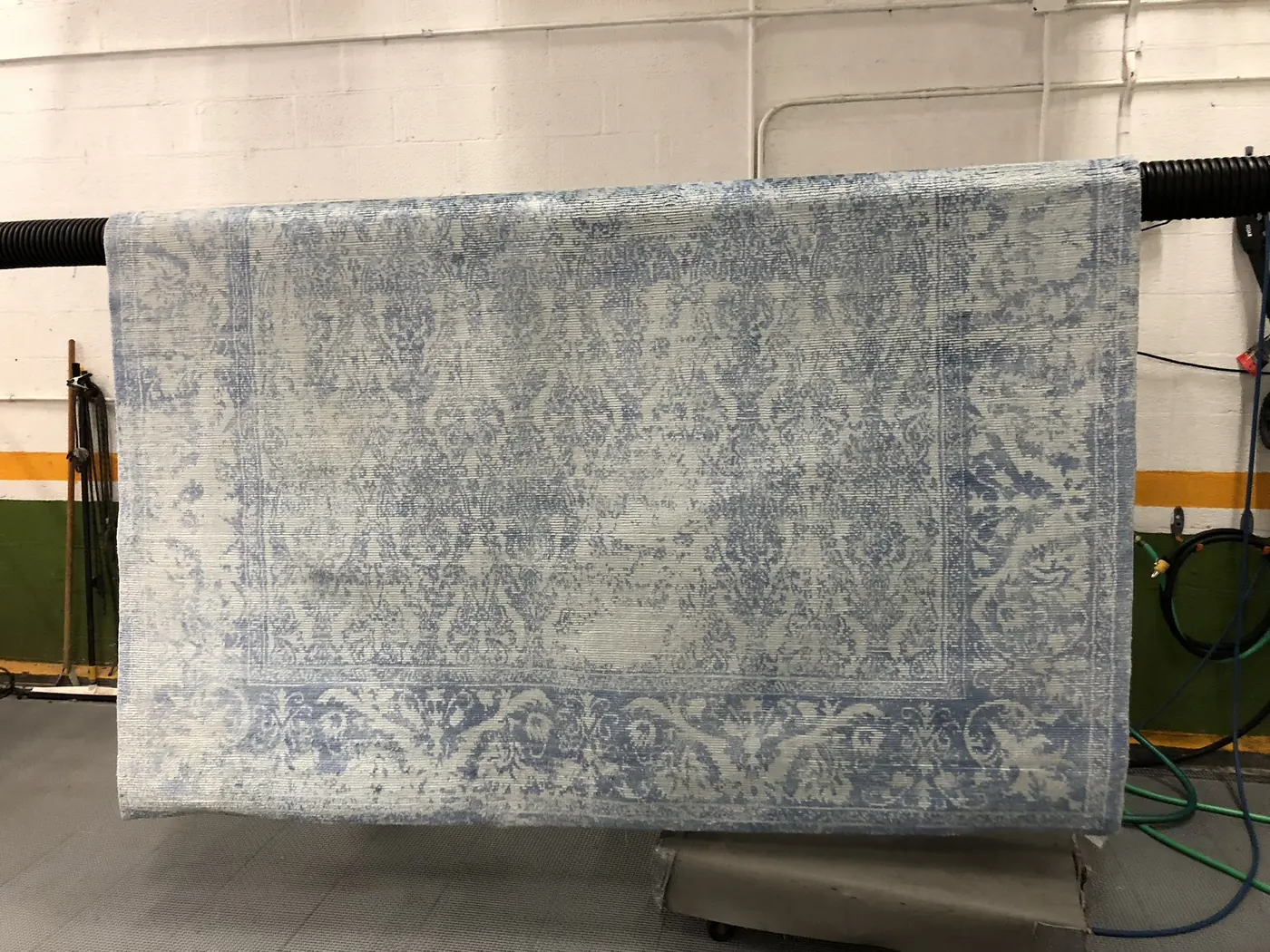 Blue-grey Oriental rug hanging after a full wash